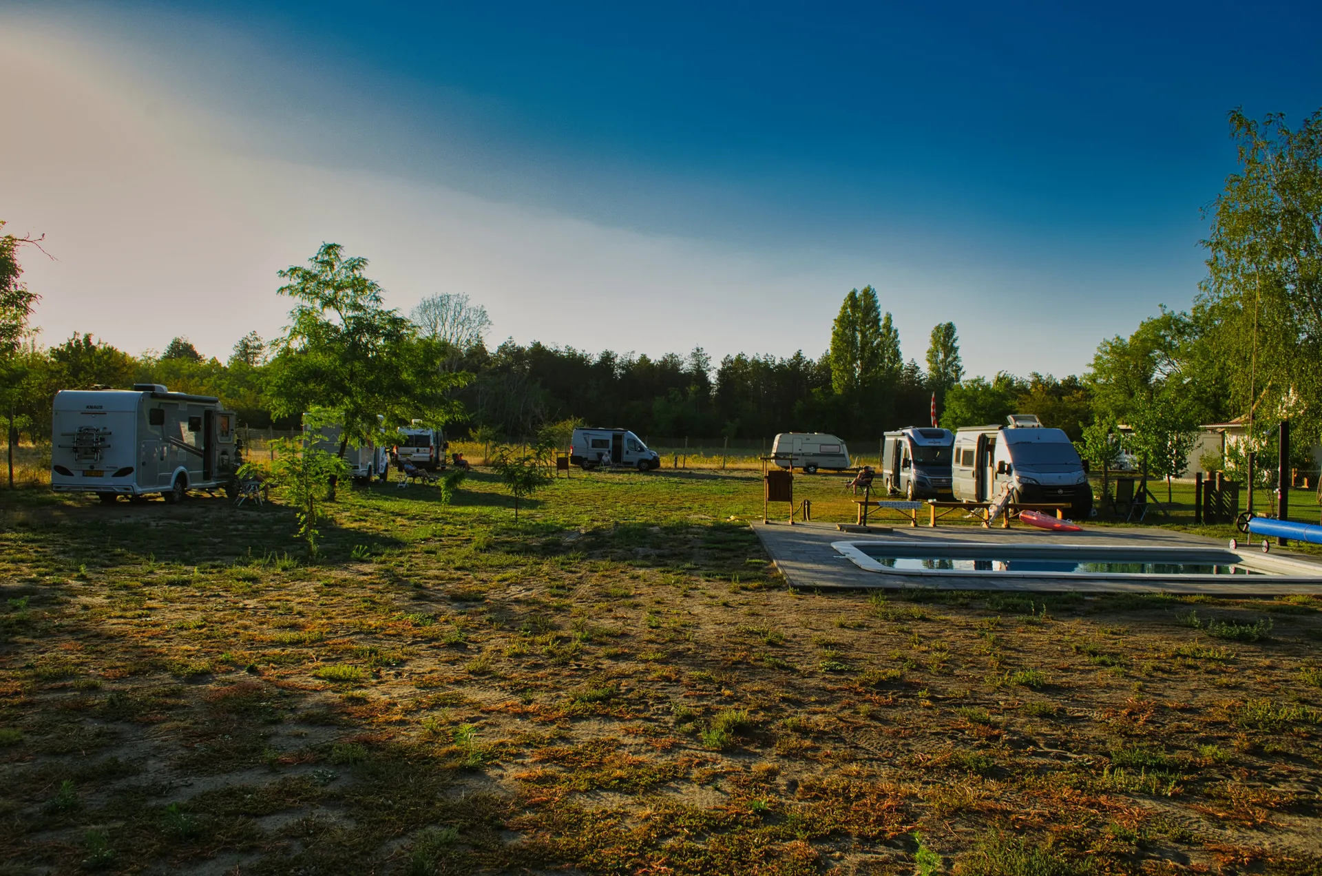 Camperveld met zwembad in avondzon